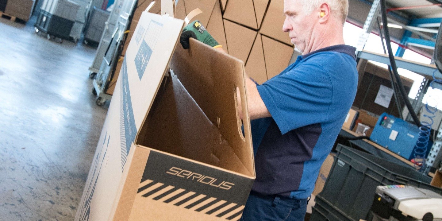 Lagerarbeiter verpackt Fahrrad Lagerarbeiter verpackt Fahrrad